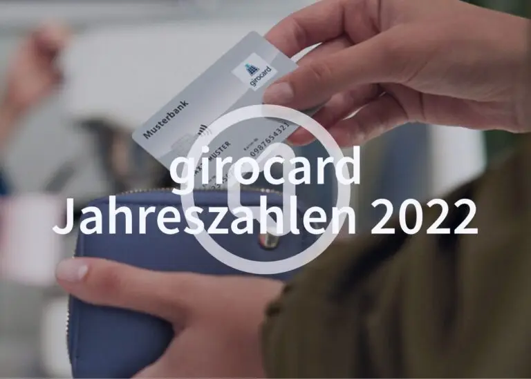 Eine Person hält eine girocard der Musterbank in der Hand, während sie in eine blaue Geldbörse greift. Im Vordergrund sind die Worte girocard Jahreszahlen 2022 zu sehen, die auf wichtige Statistiken und Informationen zu girocard-Nutzungen im Jahr 2022 hinweisen.
