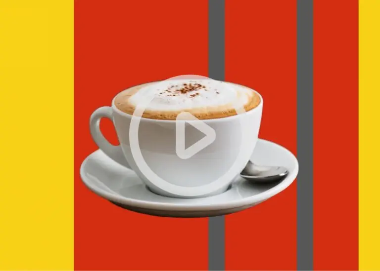 Kaffeetasse mit aufgeschäumter Milch und Zimt auf einem Unterteller vor einem bunten Hintergrund, ideal für Kaffeeliebhaber und Food-Blogger.