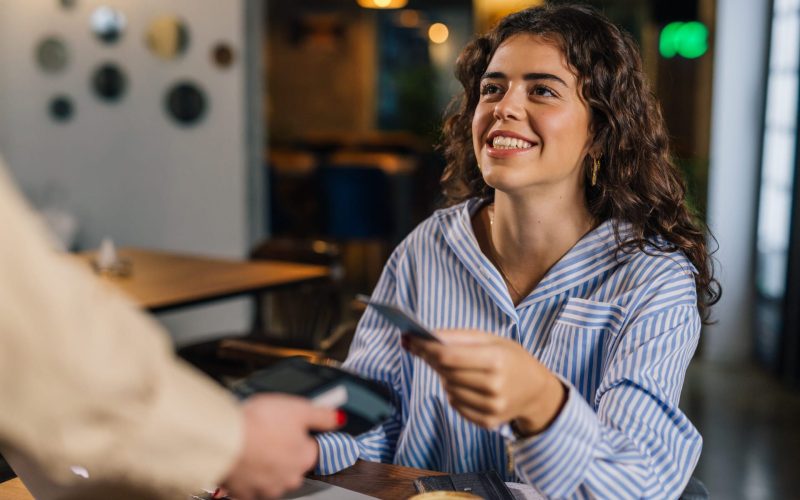 Young businesswoman pays her bill