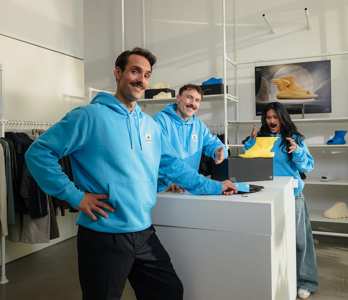 Mitarbeitende im girocard-Hoodie an der Kasse eines Modegeschäfts.