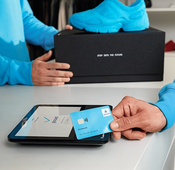 Kontaktlose Zahlung mit der girocard an einem Terminal, dessen Display das girocard-Logo zeigt.